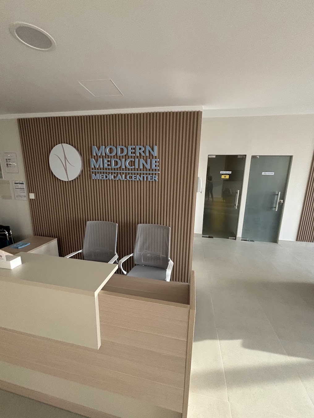 Ресепшен Modern Medicine: стойка регистрации, деревянные рейки и знак клиники