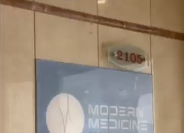 Табличка Modern Medicine и номер 2105 у входа в клинику